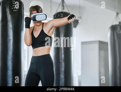 Eine gesunde, fitte und aktive Boxfrau mit einem VR-Headset, um beim Training, Training und Training im Fitnessstudio auf das Metaverse zuzugreifen. Boxerinnen machen ein Workout in virtueller Realität mit Technologie Stockfoto