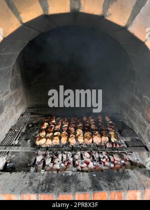 Saftige Kebabs werden auf Spießen in einem Backofen gekocht Stockfoto