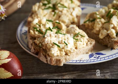 Brotscheiben mit Brotaufstrich aus hart gekochten Ostereiern und Hüttenkäse Stockfoto