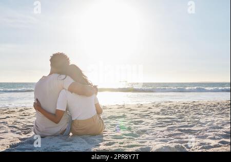 Sich Zeit für diese besonderen Momente zu nehmen. Ganzkörperaufnahme eines liebevollen jungen Paares, das einen intimen Moment am Strand teilt. Stockfoto