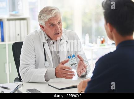 Die Hölle führt Sie in die richtige Richtung. Ein reifer Arzt, der eine Untersuchung mit einem Patienten in einem Krankenhaus hat. Stockfoto