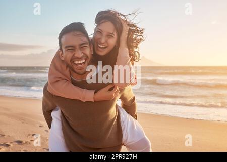 Porträt eines jungen, vielfältigen Birazialpaares, das gemeinsam am Strand Spaß hat Stockfoto