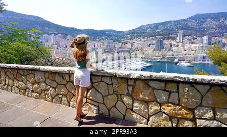 Wunderschöne Panorama-Banneransicht einer jungen Frau in voller Länge mit Blick auf die Stadtlandschaft von Monte-Carlo und den Yachthafen im Fürstentum Monaco Stockfoto