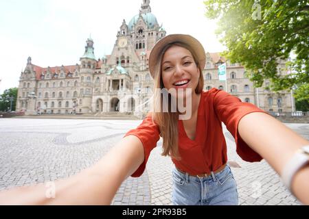 Schöne junge Frau macht Selfie-Fotos vor dem Rathaus von Hannover Stockfoto