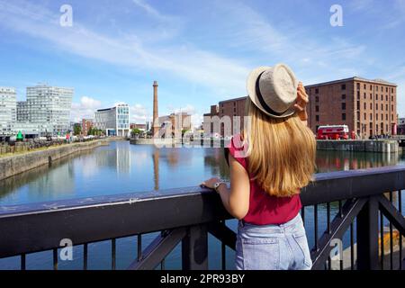 Tourismus in Liverpool, Großbritannien. Rückansicht eines Reisenden Mädchens auf der Swing Bridge beim Besuch des Royal Albert Dock in Liverpool, England. Stockfoto