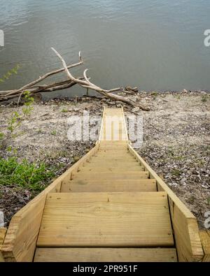 Steile Holztreppe, die am Ufer des Missouri River in Lupus, MO, zum Wasser führt Stockfoto