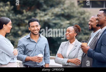 Lernen Sie meine Kollegen kennen. Eine Gruppe von Geschäftsleuten, die draußen Kaffee trinken und sich unterhalten. Stockfoto