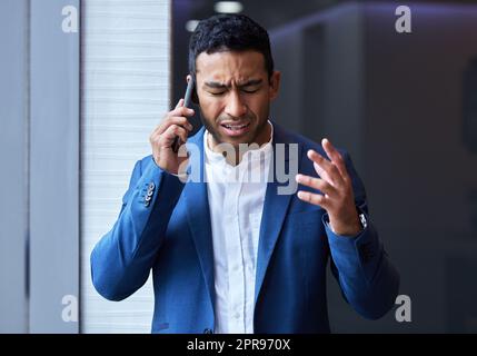 Morgen ist ein weiterer Tag, und ich glaube an Wunder. Ein junger Mann, der bei der Arbeit sein Telefon benutzt. Stockfoto