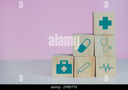 Holzwürfel Block mit Versicherung Krankenwagen medizinischen Symbol auf dem rosa Hintergrund und kopieren Raum. Stockfoto