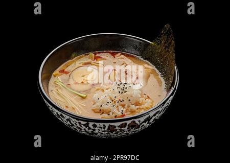 Kimchi-Tige-Suppe in einem tiefen Gericht auf einem schwarzen isolierten Hintergrund Stockfoto