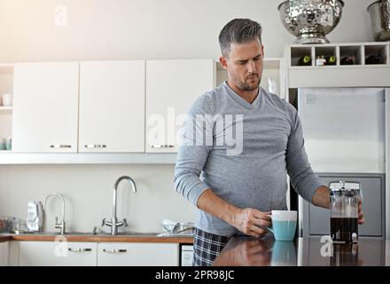 Es geht nichts über eine frische Tasse Kaffee, um den Tag zu beginnen. Ein Mann, der morgens zu Hause Kaffee trinkt. Stockfoto