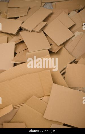 Viel Pappe liegt auf einem großen Stapel. Das Foto zeigt die Menge des Abfalls, der durch die Kartonverpackung entsteht. Stockfoto