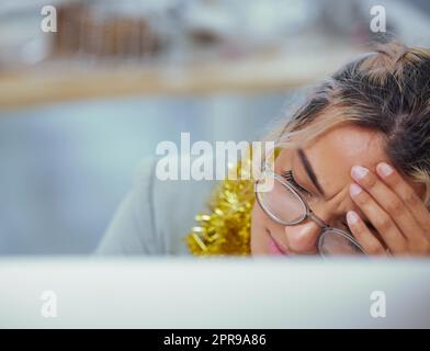 Eine junge Frau, die an ihrem Schreibtisch im Büro unter starken Kopfschmerzen leidet, hätte diese Schmerzmittel greifen sollen. Stockfoto