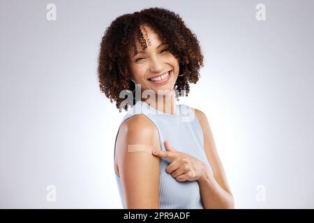 Drei Dinge im Leben, deine Gesundheit, deine Mission und die Menschen, die du liebst. Studioaufnahme einer jungen Frau nach Erhalt des Covid-19-Impfstoffes vor grauem Hintergrund. Stockfoto