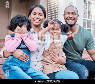 Unsere Hände sind voll, aber unsere Herzen sind noch voller. Ein Paar verbringt Zeit draußen mit ihren beiden Töchtern. Stockfoto