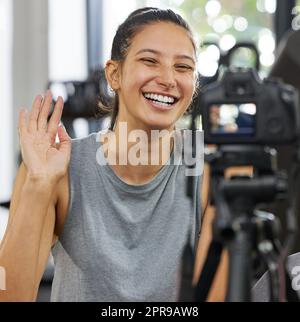 Gehen Sie selbstbewusst in die Richtung Ihrer Träume. Eine junge Frau mit einer Kamera, um für ihren Vlog in einem Fitnessstudio aufzeichnen. Stockfoto