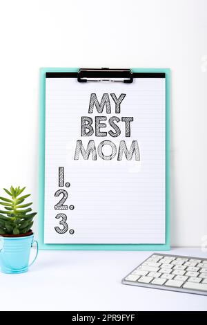 Handschriftlich auf dem Schild "Meine beste Mutter". Konzept bedeutet Bewunderung Haben Sie Zuneigung gute Gefühle Liebe zu Ihrer Mutter wichtige Botschaft präsentiert auf der Schreibtischplatte mit Blume und Tastatur. Stockfoto