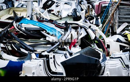 Stapel gebrauchter vorderer Stoßfänger, hinterer Stoßfänger und Spoiler des Fahrzeugs zum Recycling. Autoteile aus Kohlefaser-, PU- und PP-Kunststoff. Automobilindustrie. Schrottplatz mit alten Stoßfängern, Spoilern. Kunststoffabfälle. Stockfoto