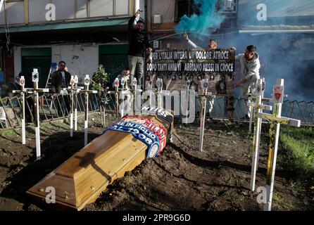 Neapel, Italien. 26. April 2023. Die Fans verbrennen neben einem Scheingrab Leuchtraketen für einen Sarg, der mit den Schals der Fußballmannschaften FC Inter FC Juventus und AC Mailand geschmückt ist, und kreuzen die Symbole aller italienischen Fußballmannschaften der Serie A vor einem SSC Napoli Fanclub. Während Neapel schon nächsten Sonntag die Fußballmeisterschaft der Serie A gewinnen könnte, sind die Vorbereitungen für die Feierlichkeiten in der Stadt in vollem Gange. Kredit: Unabhängige Fotoagentur/Alamy Live News Stockfoto