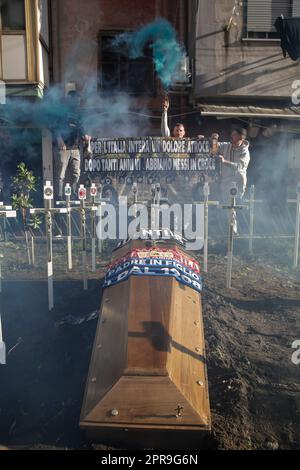 Neapel, Italien. 26. April 2023. Die Fans verbrennen neben einem Scheingrab Leuchtraketen für einen Sarg, der mit den Schals der Fußballmannschaften FC Inter FC Juventus und AC Mailand geschmückt ist, und kreuzen die Symbole aller italienischen Fußballmannschaften der Serie A vor einem SSC Napoli Fanclub. Während Neapel schon nächsten Sonntag die Fußballmeisterschaft der Serie A gewinnen könnte, sind die Vorbereitungen für die Feierlichkeiten in der Stadt in vollem Gange. Kredit: Unabhängige Fotoagentur/Alamy Live News Stockfoto