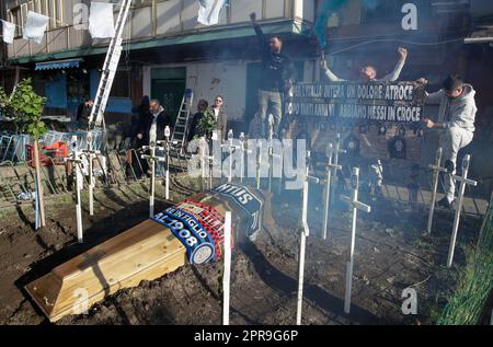 Neapel, Italien. 26. April 2023. Die Fans verbrennen neben einem Scheingrab Leuchtraketen für einen Sarg, der mit den Schals der Fußballmannschaften FC Inter FC Juventus und AC Mailand geschmückt ist, und kreuzen die Symbole aller italienischen Fußballmannschaften der Serie A vor einem SSC Napoli Fanclub. Während Neapel schon nächsten Sonntag die Fußballmeisterschaft der Serie A gewinnen könnte, sind die Vorbereitungen für die Feierlichkeiten in der Stadt in vollem Gange. Kredit: Unabhängige Fotoagentur/Alamy Live News Stockfoto