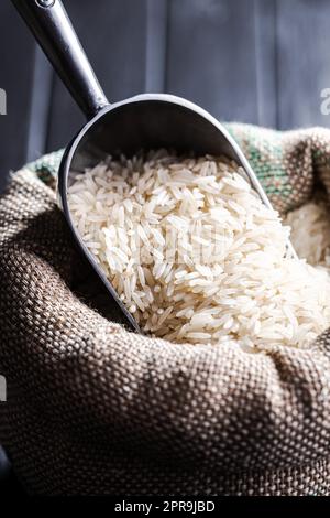 Ungekochter weißer Reis im Leinensack. Stockfoto