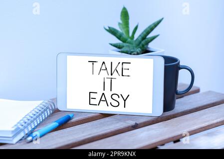 Inspiration mit Schild Take IT Easy. Konzeptfoto entspannt bleiben Sie ruhig, und lassen Sie die Sprechblase mit wichtigen Ankündigungen auf dem Tisch mit Kaffee ruhen. Stockfoto