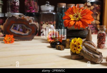 Agatized Coral mit Quarz-Kristallen und Blumen auf dem Meditationstisch Stockfoto