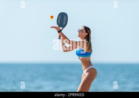 Frau spielt Strandtennis an einem Strand. Professionelles Sportkonzept. Horizontales Sport-Thema Poster, Grußkarten, Header, Website und App Stockfoto