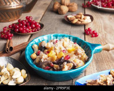 Leckerer Noah s Ark Pudding in einer cremigen Schüssel auf einem rustikalen Holztisch, traditionelle türkische Gerichte Stockfoto