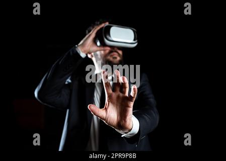 Männlicher Profi Trägt Eine Virtual-Reality-Brille, Die Gesten Trägt Und Die Moderne Lerntechnologie Vorstellt. Geschäftsmann Im Anzug, Der Im Simulator Trainiert. Stockfoto