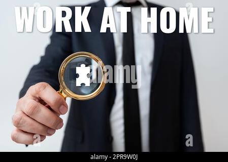 Schild mit der Aufschrift „Arbeit zu Hause“. Konzeptfoto Freiberufler arbeiten an Ihrem Haus praktische Technologie Mann hat Vergrößerungsglas, um wichtige Informationen hervorzuheben. Stockfoto