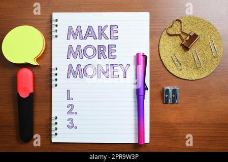 Schild mit der Aufschrift „Make More Money“. Internet-Konzept Gehaltserhöhung arbeiten Sie härter Ambition Notizbuch mit wichtigen Nachrichten am Schreibtisch mit Bürobedarf. Stockfoto