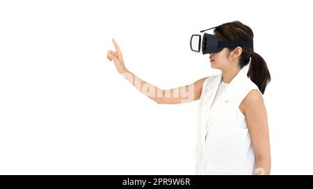 Asiatische Frau in weißem Kleid mit Virtual-Reality-Brille, spielen ein interaktives Spiel. Seitenansicht. Konzept Der Zukunftstechnologie. Stockfoto