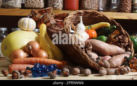 Körbe mit frischem Gemüse und Brot in der rustikalen Küche mit Gläsern mit getrockneten Speisen im Hintergrund Stockfoto