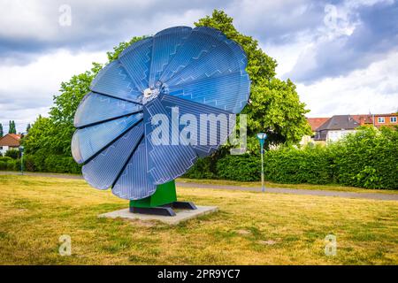 Rotierendes Solarpanel in Blumenform im Stadtpark. Photovoltaik, alternative Stromquelle Stockfoto