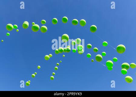 Grüne Ballons an einem blauen Himmel Stockfoto