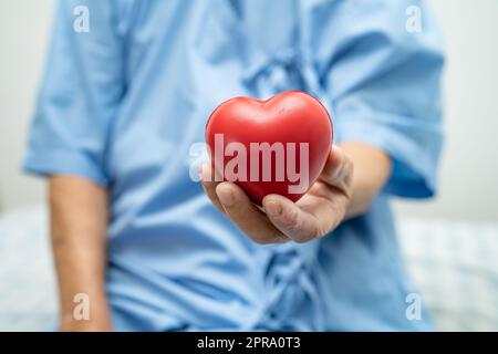 Asiatische ältere oder ältere alte Dame Frau Patientin mit rotem Herzen, gesunde starke medizinische Konzept. Stockfoto