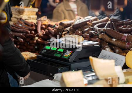 Ein Stück Fleisch auf elektronischem Maßstab gewogen, traditioneller festlicher Marktstand, viele verschiedene Fleischsorten, die verkauft, gekauft und verkauft werden Stockfoto