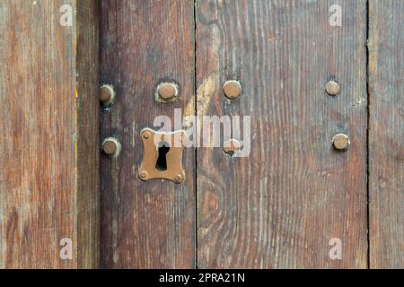 Schlüsselloch in alter Holzkriechtür Stockfoto