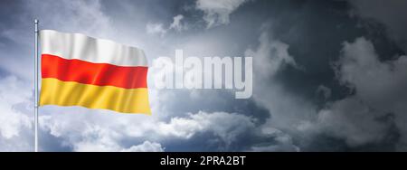 Südossetische Flagge am bewölkten Himmel Stockfoto