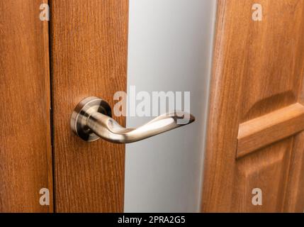 Externer Türgriff ohne Schutzschloss am Holzrahmen. Stockfoto