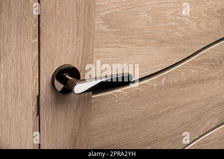 Externer Türgriff ohne Schutzschloss am Holzrahmen. Stockfoto