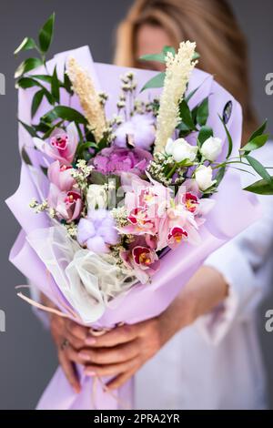 Nahaufnahme eines großen festlichen Straußes in den Händen einer unbekannten Frau. Stockfoto