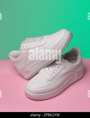 Werbefoto eines neuen weißen Sneakers für Damen oder Jugendliche mit farbigem Hintergrund. Stockfoto