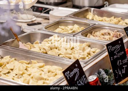 Metallbehälter voller frisch zubereiteter, köstlicher, dampfender polnischer Pierogi, Restaurant, traditioneller festlicher Markt, Catering-Service, einfacher Nachteil Stockfoto