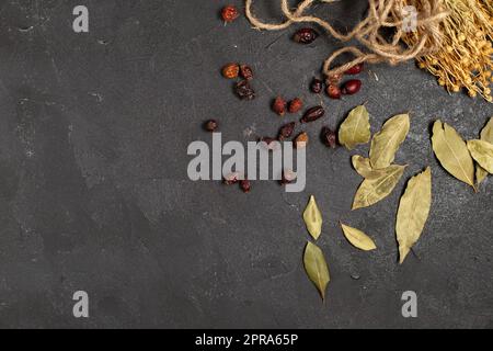 Draufsicht getrocknete grüne Blätter zusammen mit braunen getrockneten Früchten auf dunklem Hintergrund trockenes Blatt Stockfoto