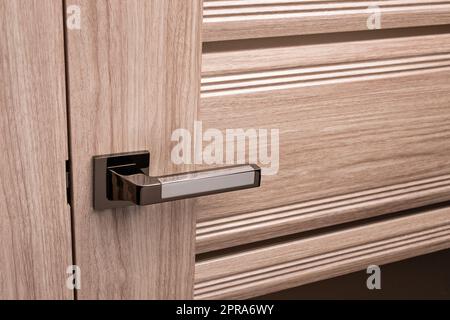 Externer Türgriff ohne Schutzschloss am Holzrahmen. Stockfoto