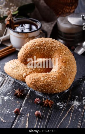 Nahaufnahme eines großen süßen Bagels auf einem dunklen rustikalen Holztisch. Stockfoto