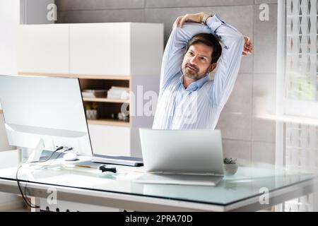 Rückansicht Eines Geschäftsmanns, der seine Arme streckt Stockfoto